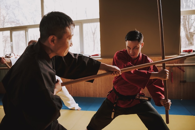 Combattenti di arti marziali di Kung Fu che combattono con i bastoni