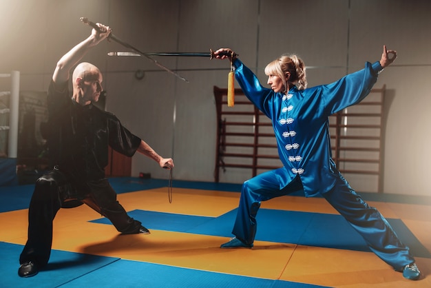 Combattenti Wushu, uomo e donna con le spade