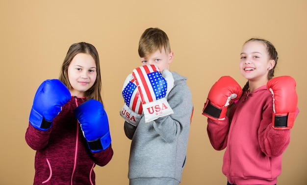 Combattimento amichevole. Ragazzi e ragazze amici indossano guantoni da boxe con bandiera usa. concetto di sport americano. Bambini sportivi che praticano abilità di boxe. Sport di boxe. Inizia la carriera di pugile. Abilità di autodifesa.