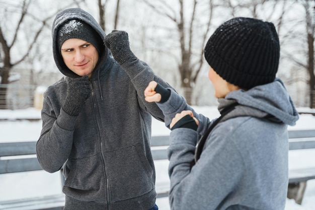 Combattimento di coppia atletica durante l'allenamento invernale nel parco cittadino innevato