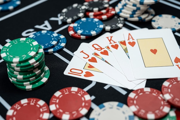 Combinazione di royal flush in cinque carte di poker con chip al tavolo del casinò carte di blackjack di gioco d'azzardo