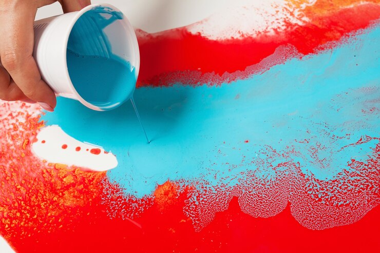 Foto come realizzare la pittura acrilica. lavori in corso. mano femminile che tiene un bicchiere di plastica con vernice blu.