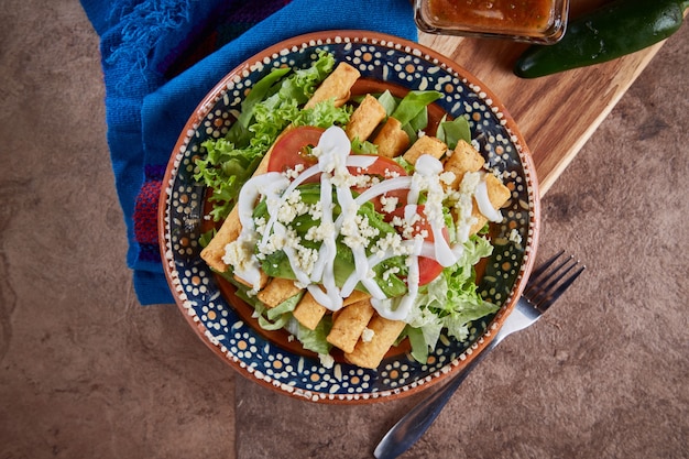 Comida mexicana tacos dorados o flautas de pollo con lechuga queso crema y tomate