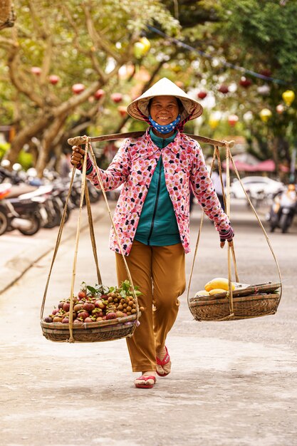 Commessa di frutta con cappello vietnamita