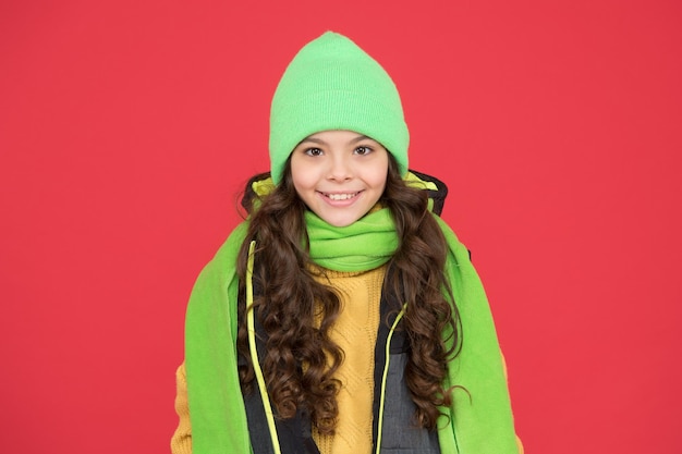 Comodo abbigliamento invernale per il giovane esploratore Bambino felice con look invernale sfondo rosso Bambino piccolo indossa abiti caldi Guardaroba invernale per bambini attivi Moda e stile Stile invernale all'aperto