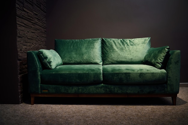 Comodo divano imbottito verde velour esposto per la vendita nello showroom del negozio di mobili Esposizione di mobili imbottiti