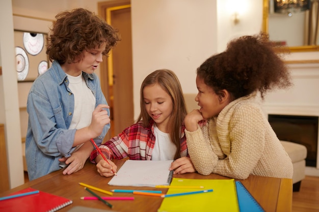 Compagne di classe. Un gruppo di ragazzi che preparano insieme i compiti a casa e aiutano il compagno di classe