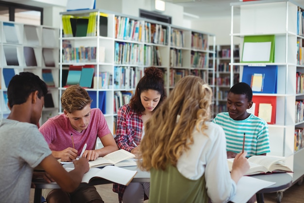 Compagni di classe attenti che studiano in biblioteca