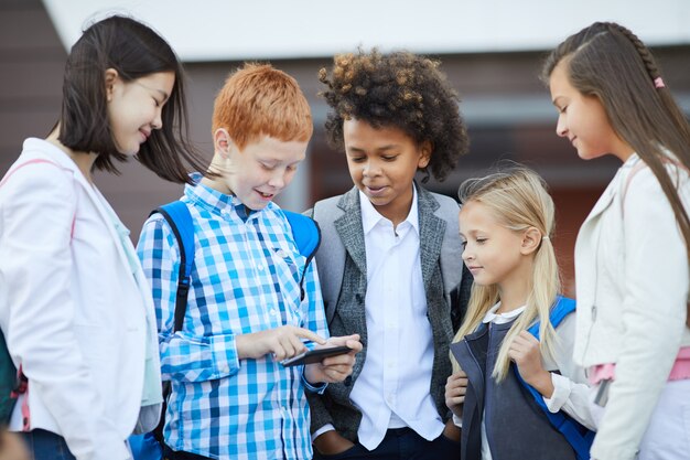 Compagni di classe che giocano al telefono