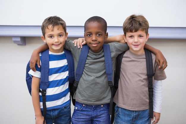 Compagni di classe che sorridono alla macchina fotografica in aula