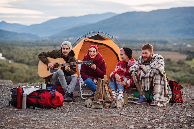 Compagnia di giovani amici che fanno un picnic in montagna