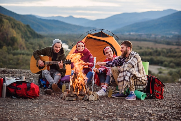 Compagnia di giovani amici che fanno un picnic in montagna