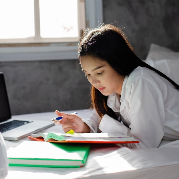 Compiti asiatici della donna sul letto