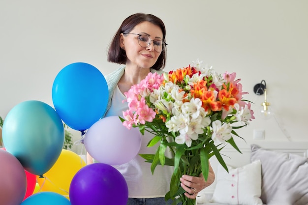 Compleanno 45 anni femmina felice con bouquet di fiori e palloncini