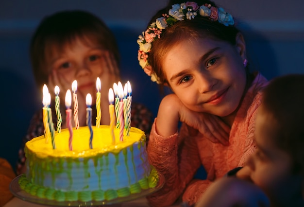 Compleanno di bambini. Bambini vicino a una torta di compleanno con candele.