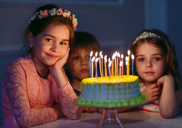 Compleanno di bambini. Bambini vicino a una torta di compleanno con candele.