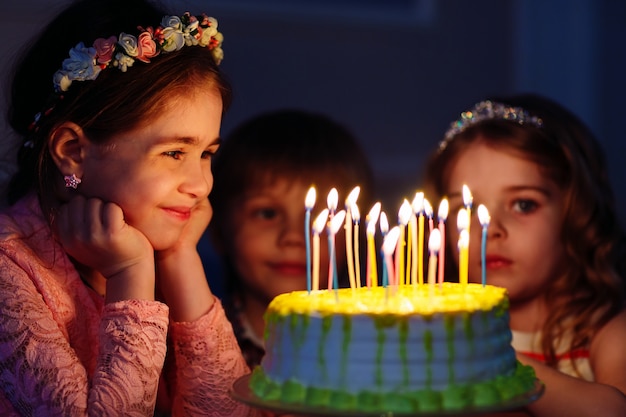 Compleanno di bambini. Bambini vicino a una torta di compleanno con candele.