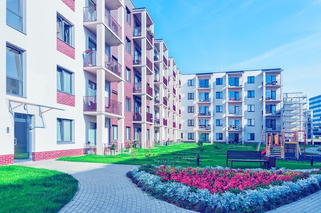 Complesso di nuovi edifici residenziali con parco giochi per bambini e vaso di fiori come strutture esterne.