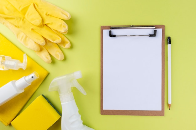 Completa la pulizia degli oggetti sulla parete verde con blocco note bianco Concetto di pulizia.