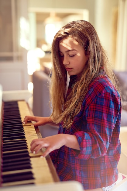 Comporre il suo capolavoro musicale Inquadratura ritagliata di una giovane ragazza che suona il piano