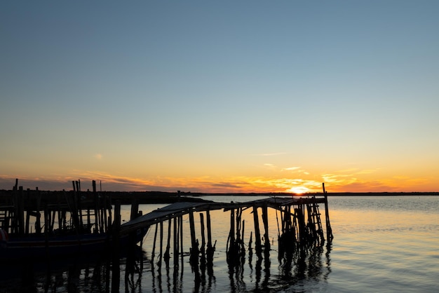 Comporta molo su palafitte in legno al tramonto a Setbal Portogallo