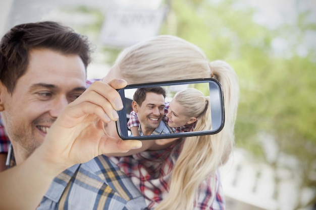 Composito di coppia che si fa selfie su smartphone