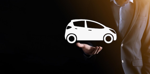 Composito Digitale dell'uomo che tiene l'icona dell'auto. Assicurazione automobilistica per auto e concetto di servizi per auto. Uomo d'affari con gesto d'offerta e icona dell'auto.