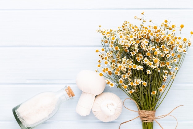 Composizione aromaterapia con cosmetici naturali e fiori di camomilla sulla luce