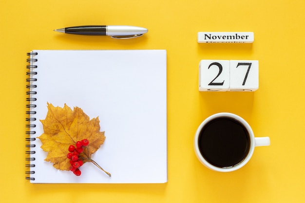 Composizione autunnale. Calendario in legno 27 novembre tazza di caffè