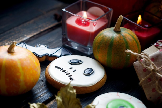 Composizione autunnale con pan di zenzero per candele di halloween zucche e lasciare sul tavolo di legno