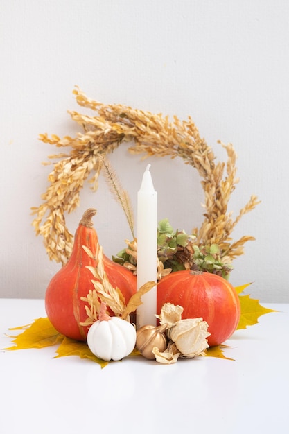 Composizione autunnale Foglie secche ghirlanda di zucche e candele su sfondo bianco Autunno autunno e concetto di giorno del ringraziamento Natura morta