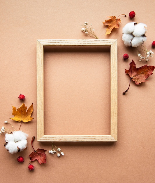 Composizione autunnale. Photo frame, fiori, foglie su sfondo marrone. Autunno, caduta, concetto di giorno del ringraziamento. Appartamento laico, vista dall'alto, copia dello spazio