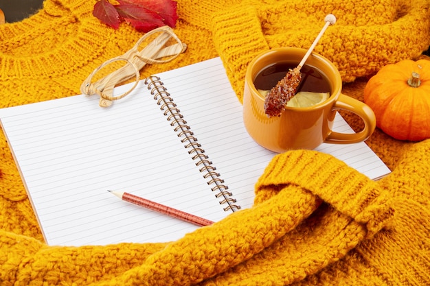 Composizione autunnale piatta con tè e un caldo maglione di lana