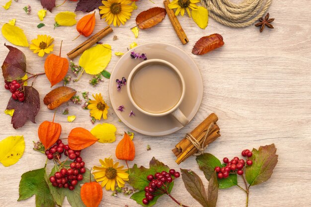 composizione autunnale tazza di caffè su un tavolo con fiori e foglie vista dall'alto immagine di sfondo