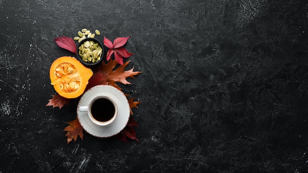 Composizione autunnale Una tazza di caffè e foglie autunnali colorate distese su uno sfondo di pietra nera Vista dall'alto Spazio libero per il testo