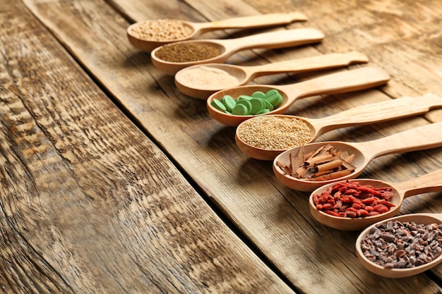 Composizione con assortimento di prodotti superfood in cucchiai di legno sul tavolo