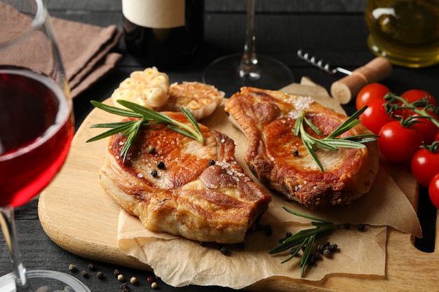 Composizione con bistecche fritte e vino. Cibo alla griglia