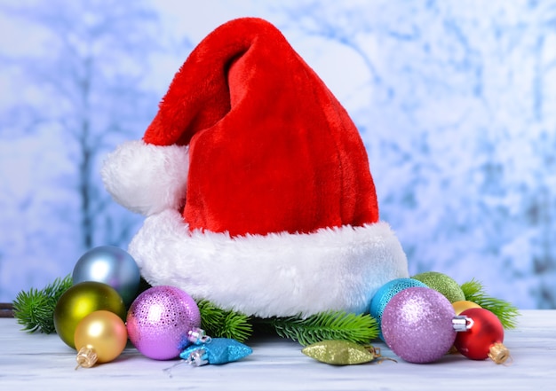 Composizione con cappello rosso di Babbo Natale e decorazioni natalizie su sfondo chiaro