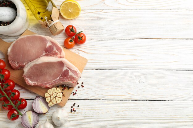 Composizione con carne cruda per bistecca e ingredienti su fondo in legno