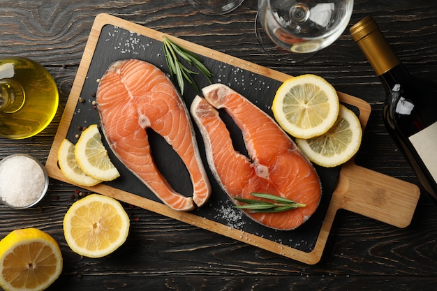 Composizione con carne di salmone e spezie su fondo di legno, vista dall'alto