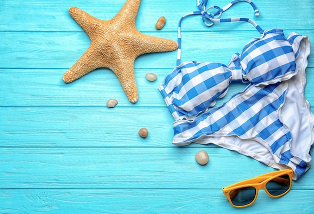 Composizione con costume da bagno e occhiali da sole su fondo in legno Concetto di vacanza