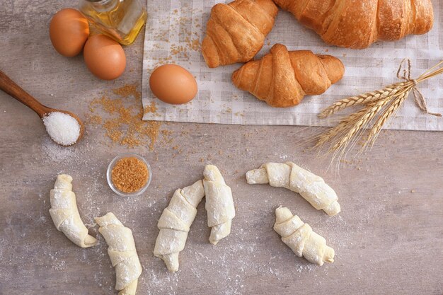 Composizione con croissant crudi e cotti sul tavolo