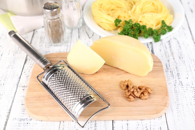 Composizione con formaggio grattugiato gustoso spaghetti sul fondo della tavola in legno