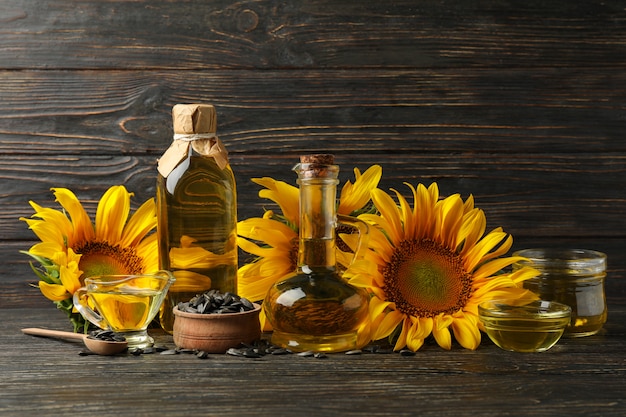 Composizione con girasole, olio e semi su fondo in legno