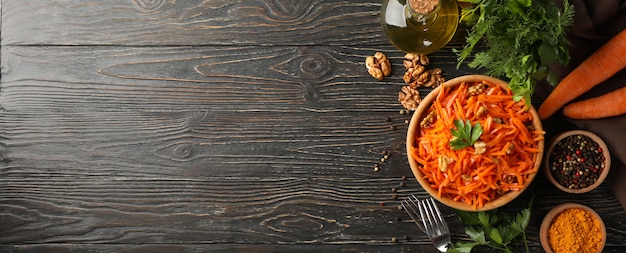 Composizione con gustosa insalata di carote su fondo in legno