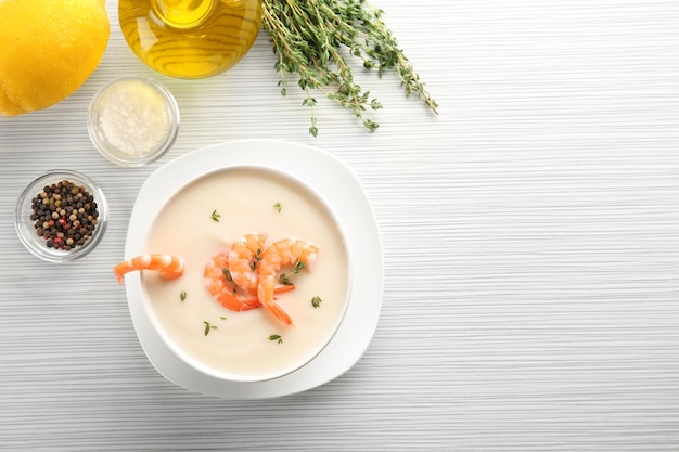 Composizione con gustosa zuppa di crema di gamberi sulla tavola di legno