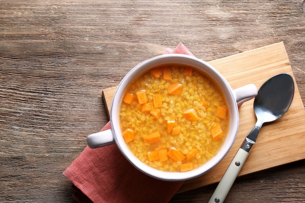 Composizione con gustosa zuppa di lenticchie sulla tavola di legno