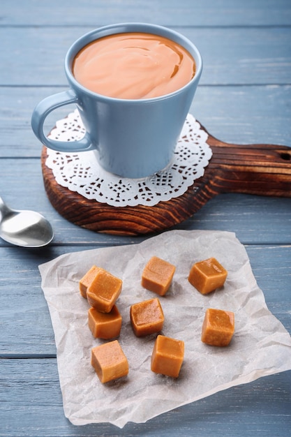 Composizione con gustose caramelle al caramello su sfondo di legno