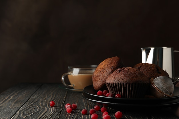 Composizione con gustosi muffin e bevanda al cacao su legno