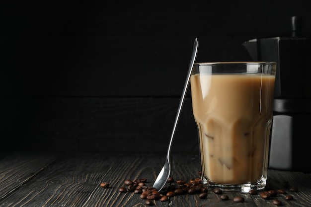 Composizione con il caffè di ghiaccio e semi di caffè su fondo di legno